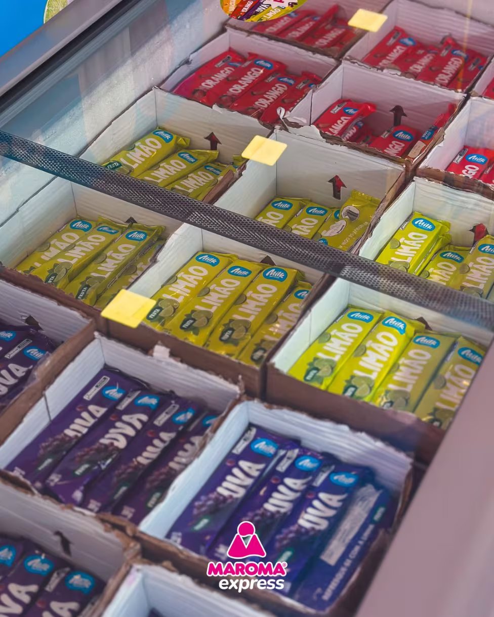 Freezer da loja repleto de picolés de fruta nos sabores limão, uva e morango