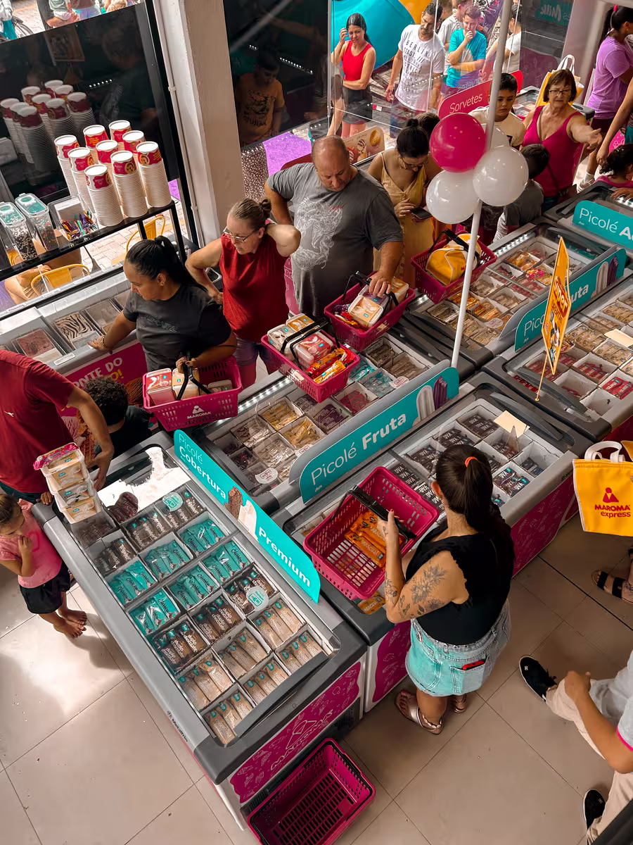 Loja Maroma Express cheia de clientes na inauguração, com freezers de picolés e sorvetes
